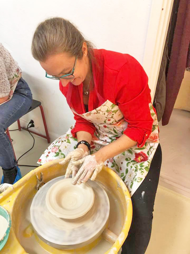 Woman creating pottery on wheel